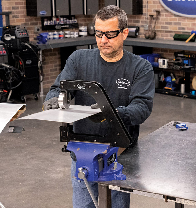 Fabricator forming sheet metal on the vise-mounted Eastwood Elite Mini English wheel